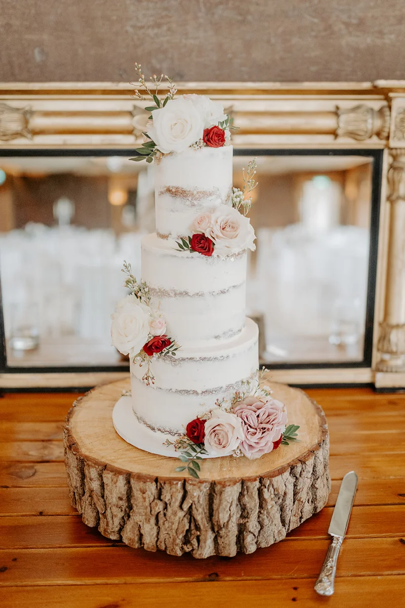 Three tier white wedding cake with real flowers by Vanilla pod at a wedding in the cotswolds
