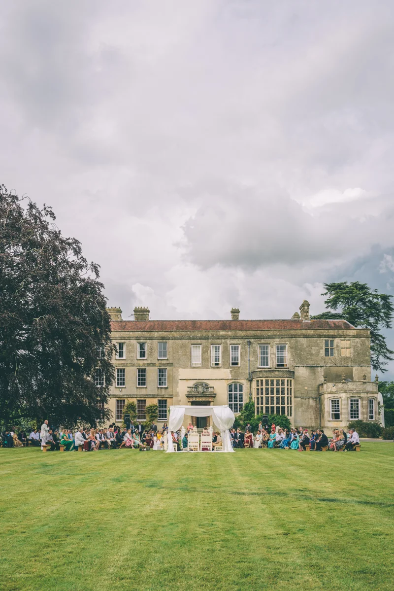 Indian Outdoor wedding ceremony in a white mandap on the lawn in front of the house