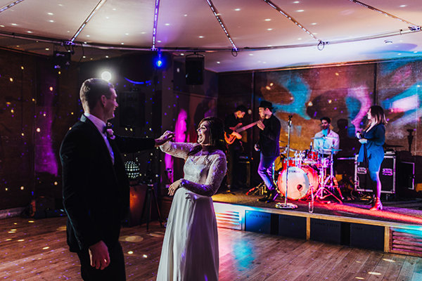 First dance couple laugh in front of amazing wedding band at elmore court soundproof late night party venue