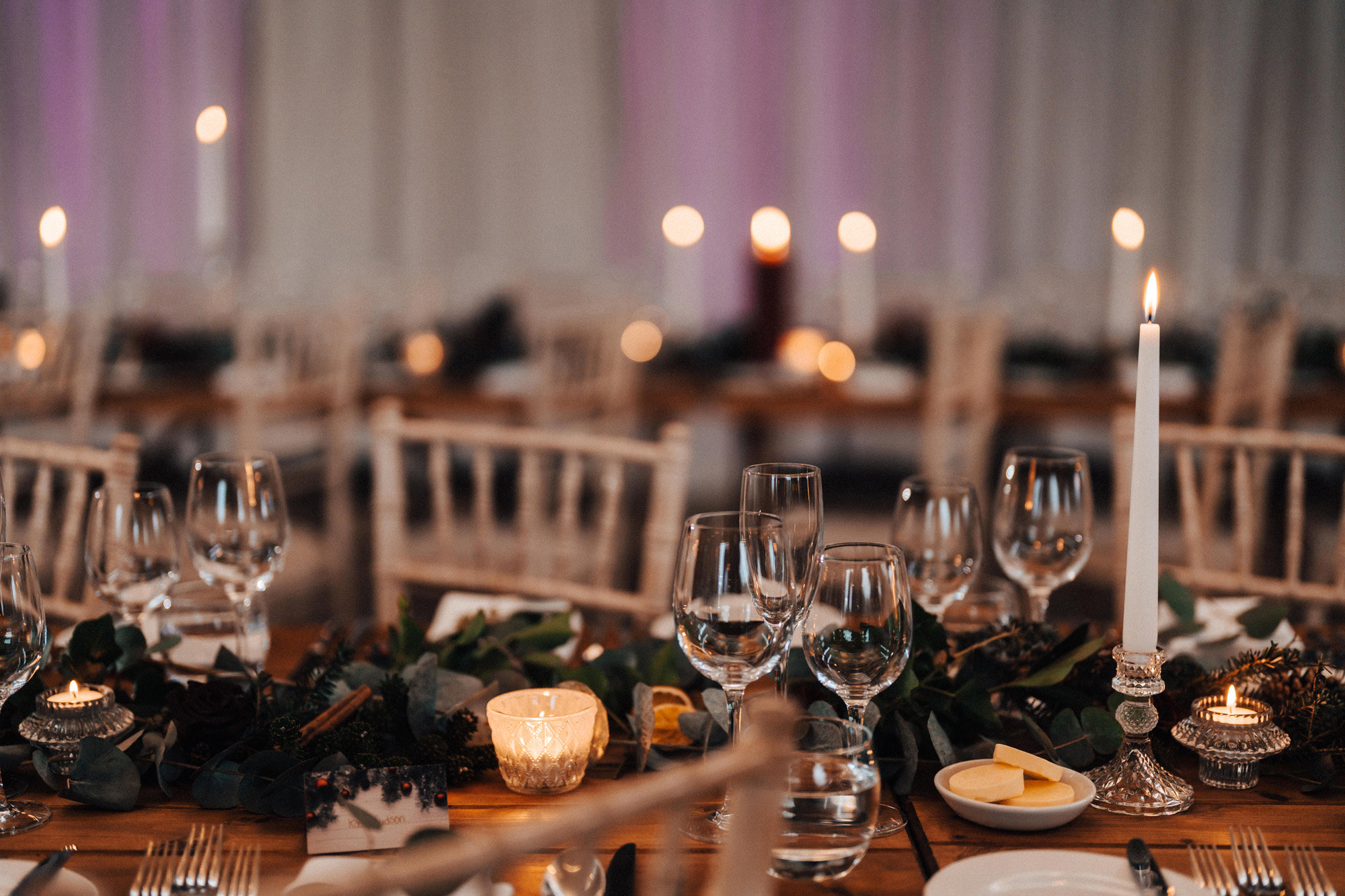 christmas wedding decor and candles on tables at winter wedding reception venue in the cotswolds