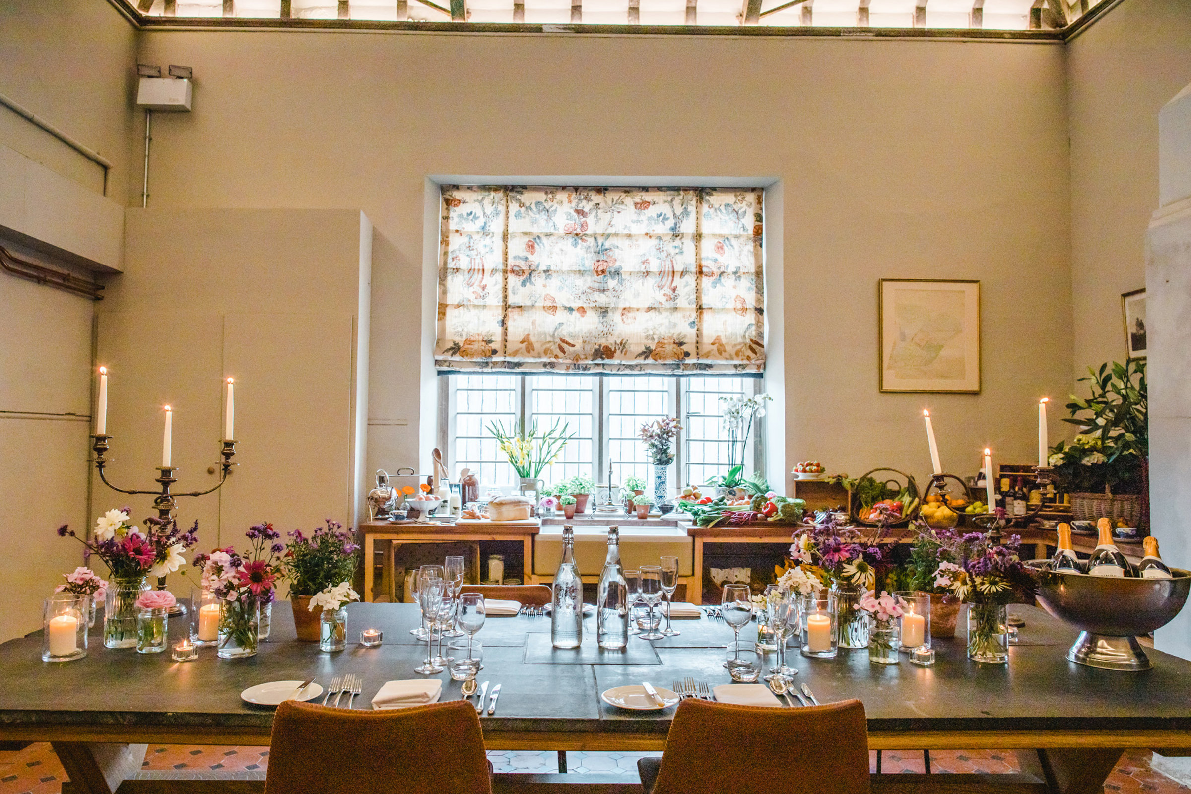 Beautiful candlelit meal with fresh flowers for a Wedding tasting in the Victorian kitchen at Elmore Court