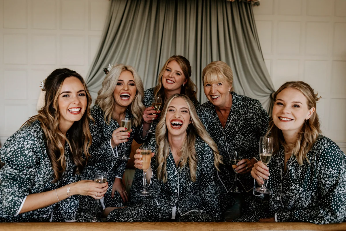 beautiful bridal party dressed in pyjama's enjoying a glass of bubbles on the morning of a wedding
