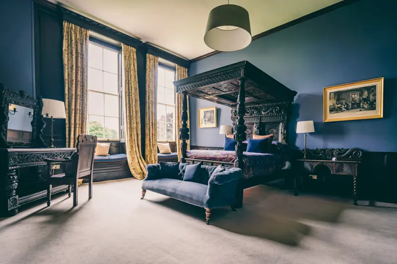 Intricately carved antique French four poster bed at Elmore Court dates back to 1633 situated in The Oak Room with 17th century fireplace and copper bath for a romantic wedding night