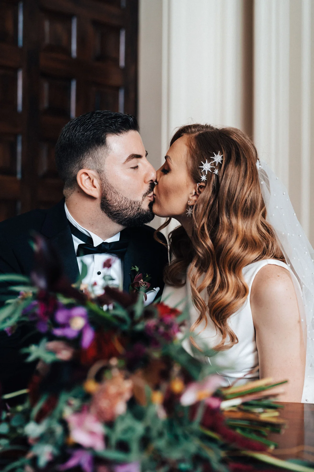 autumn wedding ceremony with celestial details couple kiss signing register