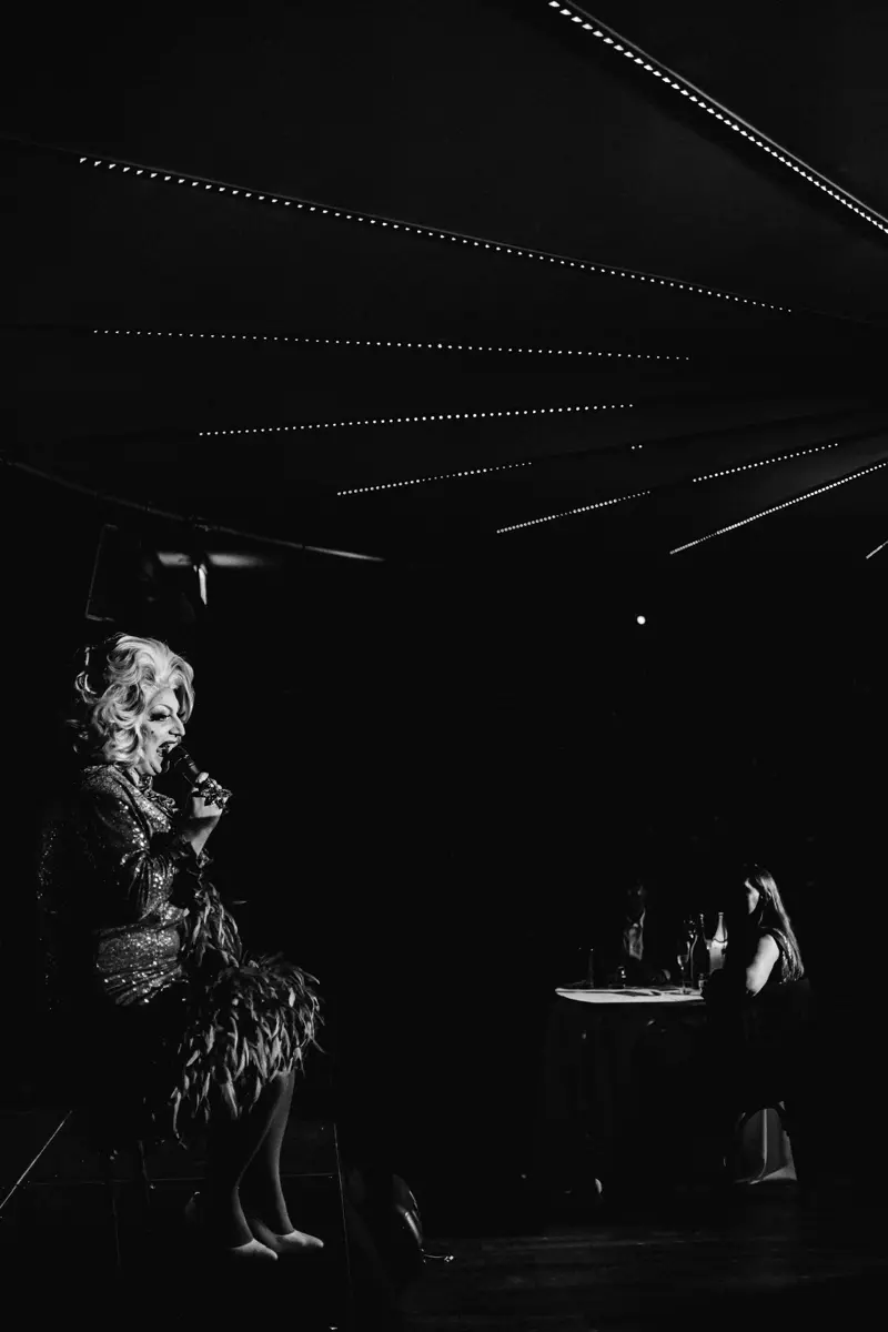 Cabaret drag queen in black and white on stage at elmore court
