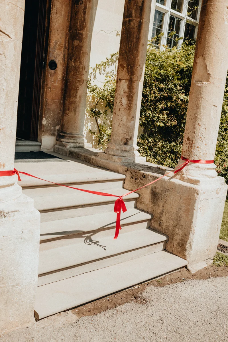 red bow between two columns of a porch at a wedding venue in Gloucestershire