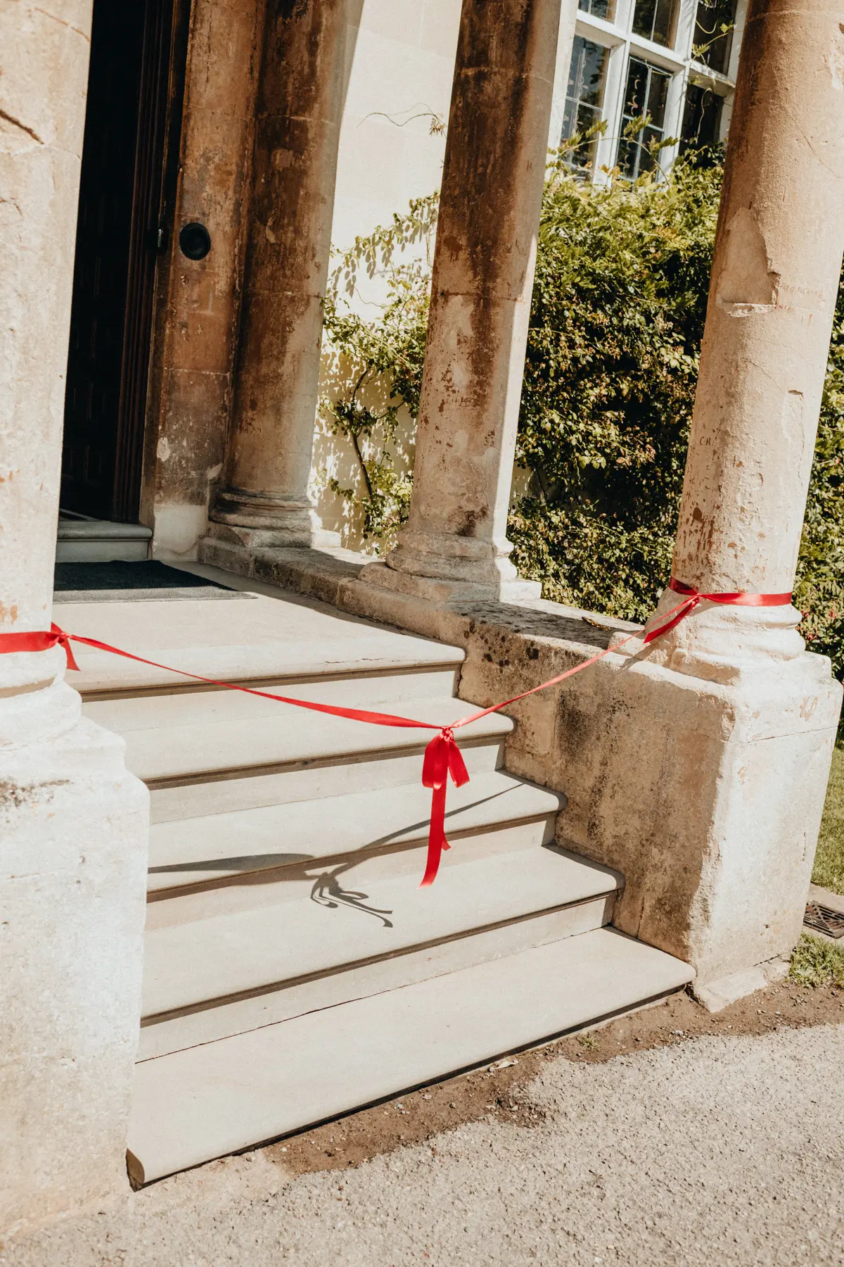red bow between two columns of a porch at a wedding venue in Gloucestershire