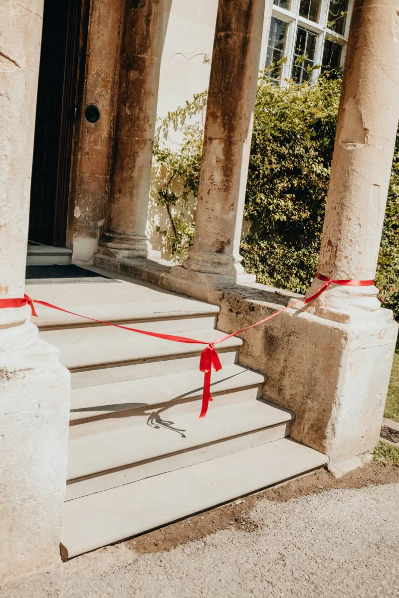 red bow between two columns of a porch at a wedding venue in Gloucestershire