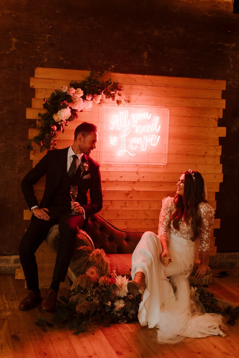 all you need is love boho wedding couple in front of their pretty details for september wedding