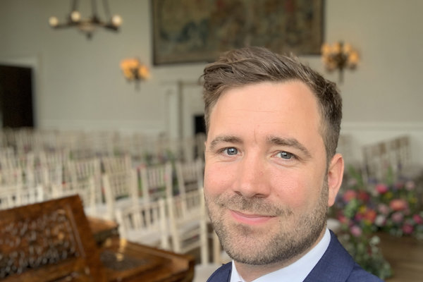 Wedding pianist sitting at piano in beautiful stately home wedding venue in the uk