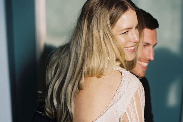 Beautiful bride sitting on her husbands lap as they pose for their wedding photographs