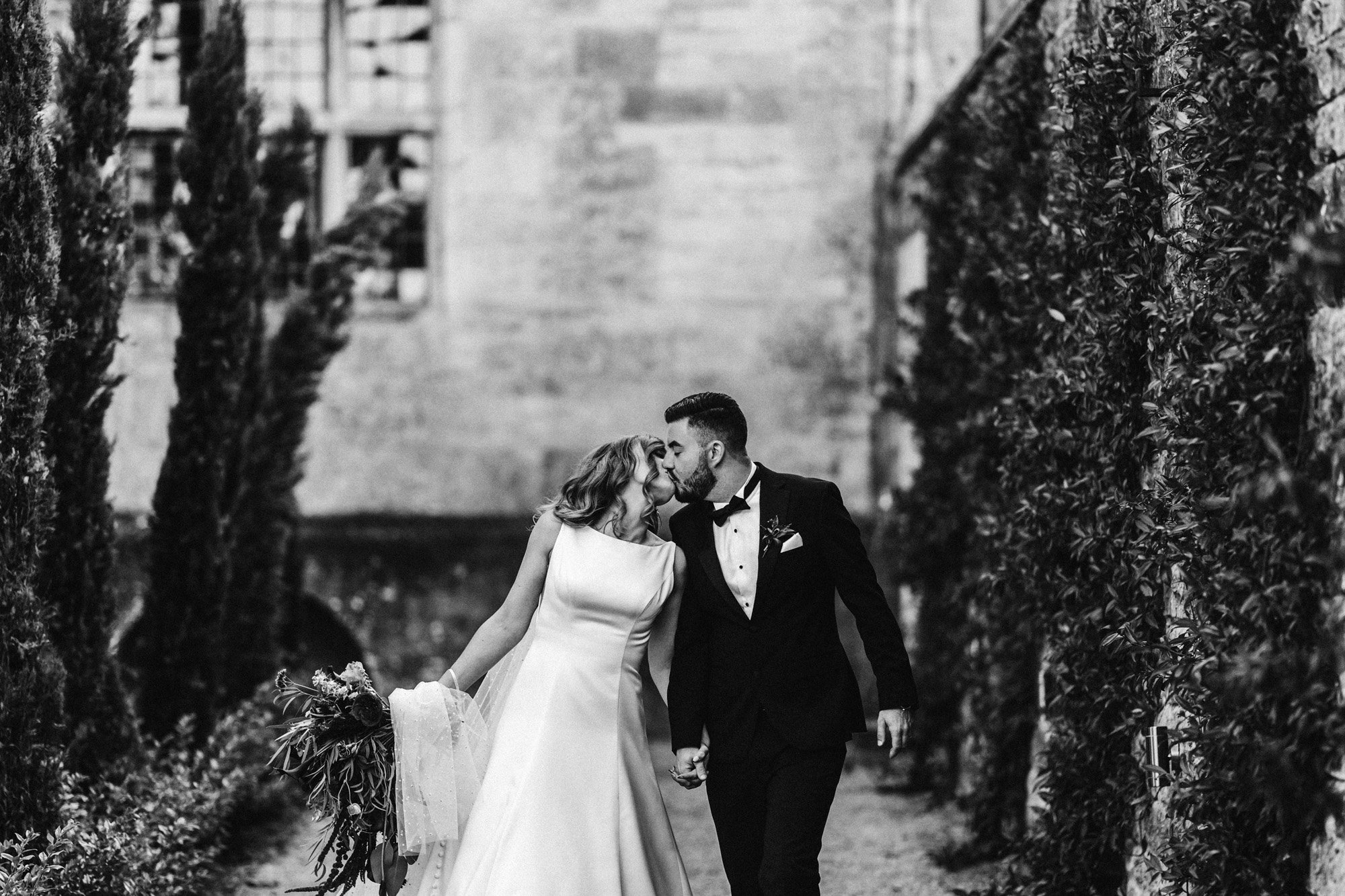 black tie bride and groom kiss in black and white photo of autumn wedding at elmore court