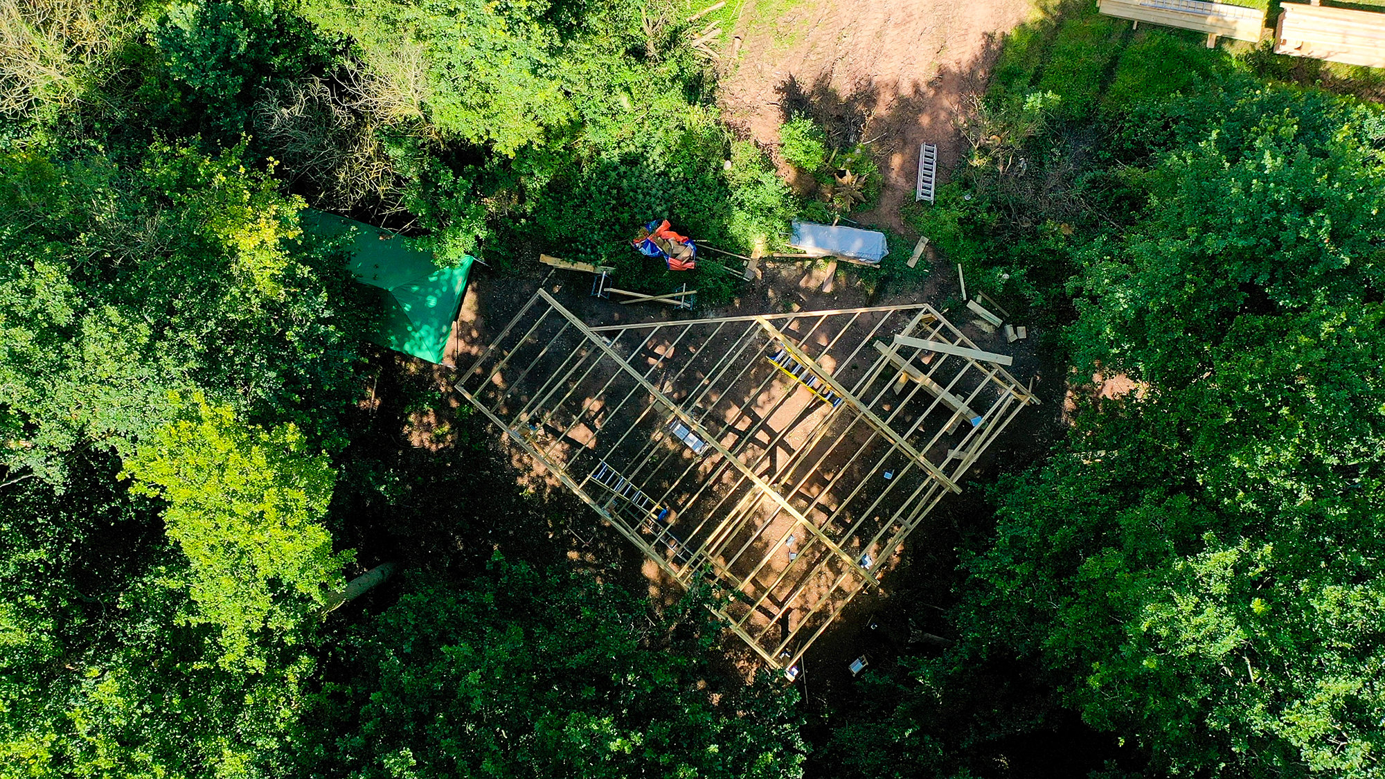 Ariel view of the decking of a treehouse in construction; nestled in a beautiful Cotswold woodland