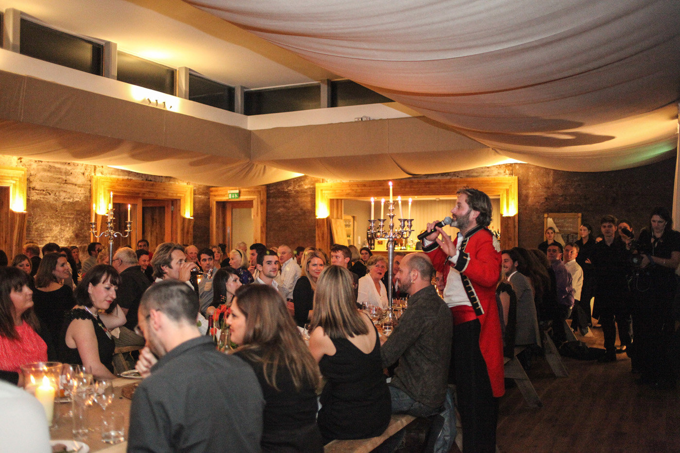 Hamish Guerrini entertains the crowd at funny dinner speech in the gillyflower festival wedding venue in gloucestershire