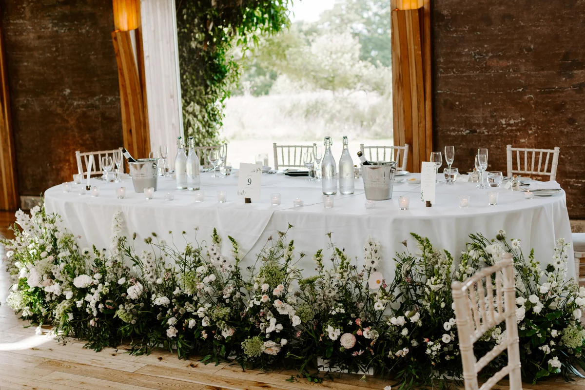 wild meadow style wedding flowers around the bottom of the top table at a wild wedding at elmore court