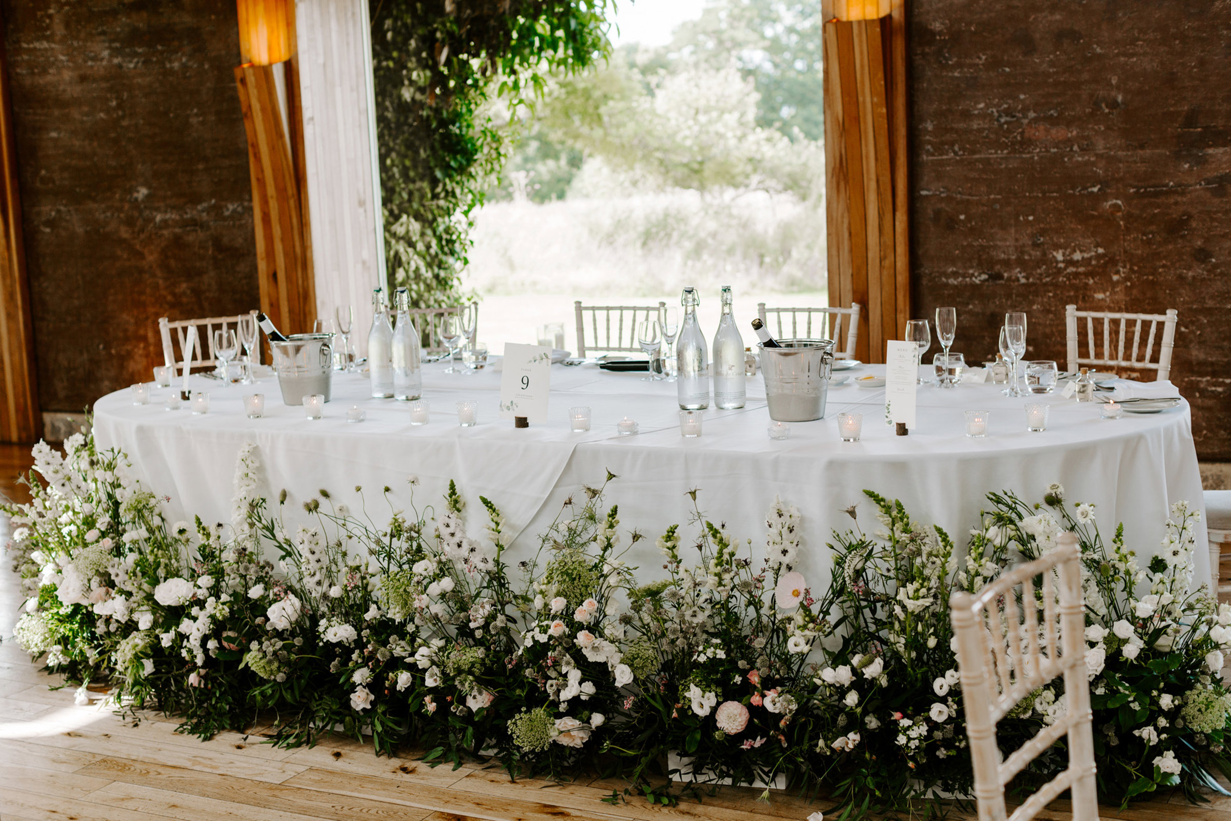 wild meadow style wedding flowers around the bottom of the top table at a wild wedding at elmore court