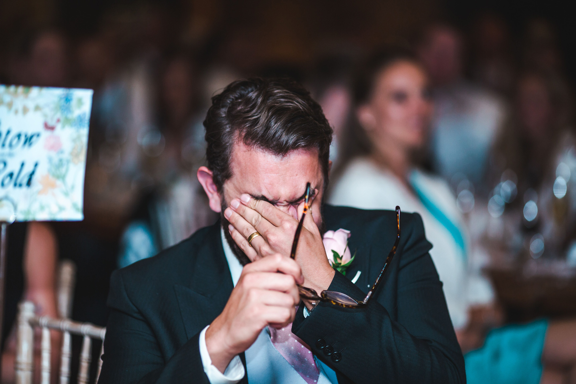 Groom holds his face in his hands and cries during speeches