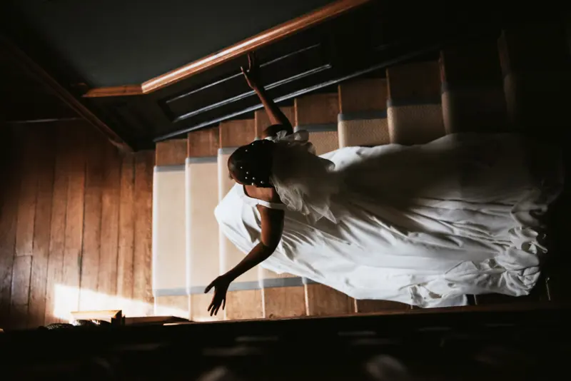 bride in white dress walking down the stairs of a stately home in Gloucestershire