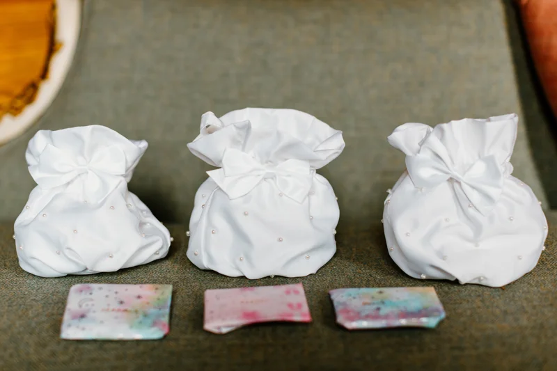 Little white bags dotted with pearls for wedding guests gifts
