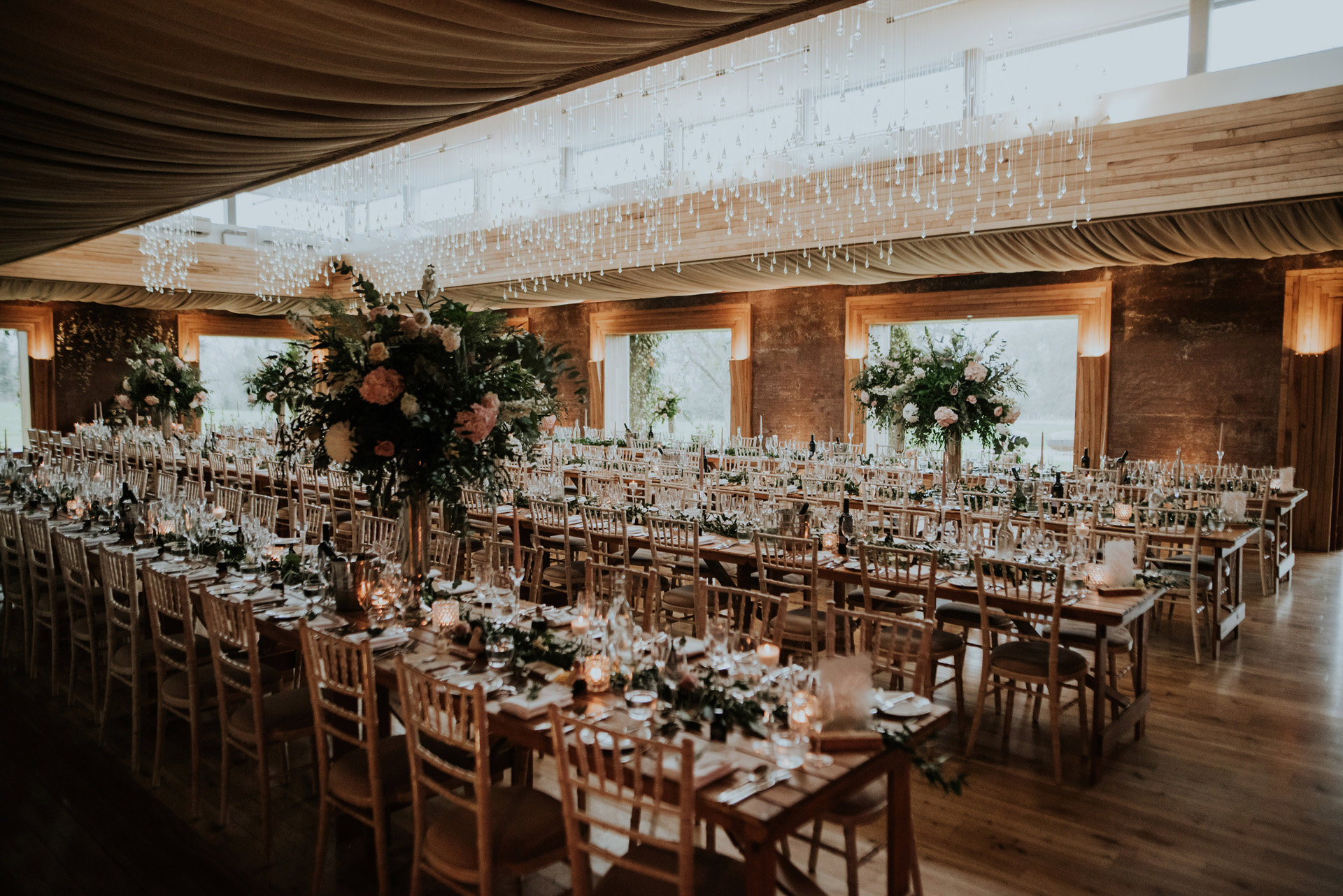 Boho wedding reception with long banquet tables candles and foliage in March
