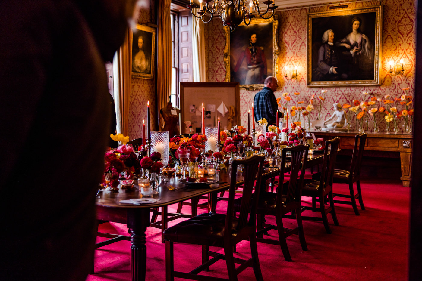 Hot pink and red wedding inspiration in the dining room at stately home wedding venue elmore court with paintings of ancestors and red carpet and wallpaper and antique furniture