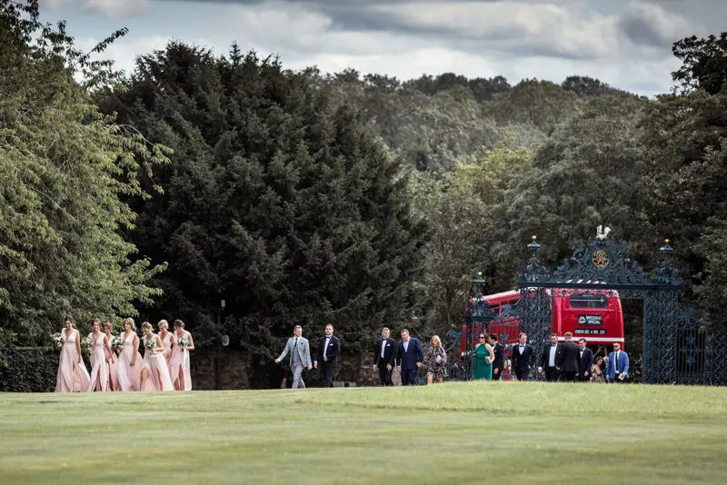 Bridal party get off an Old Double decker bus at the gates of Elmore Court