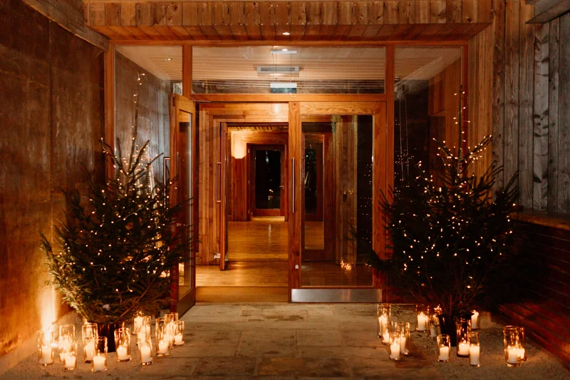 fairy lights on trees with candles scattered below them, at the entrance to the gillyflower at Elmore Court