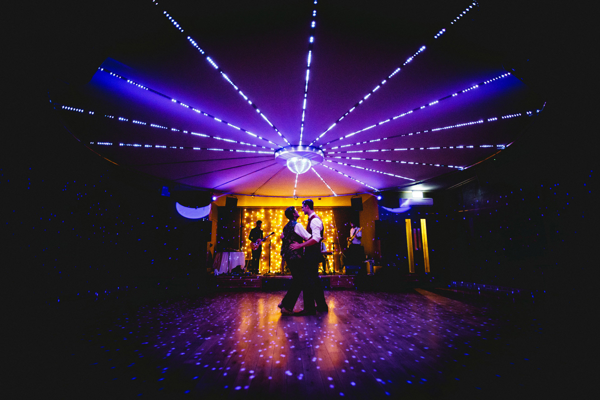 two grooms first dance on purple lit dance floor at beautiful gay hindu wedding celebration at elmore court