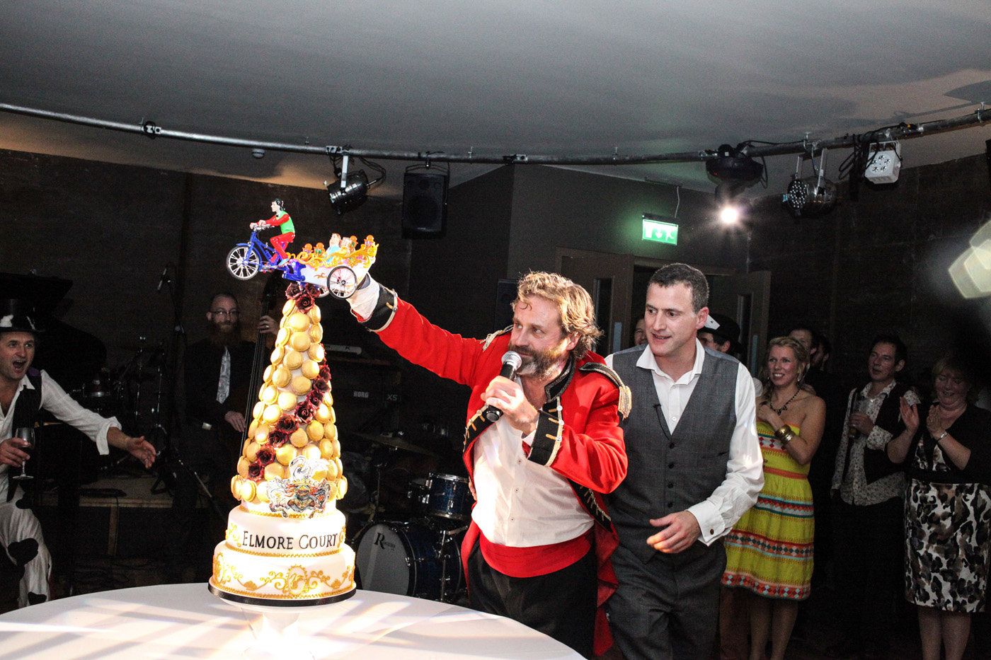 Anselm Guise and Hamish Geurrini of rabbit hole glastonbury with huge tower cake and toy car funny festival entertainment at launch party of wedding venue
