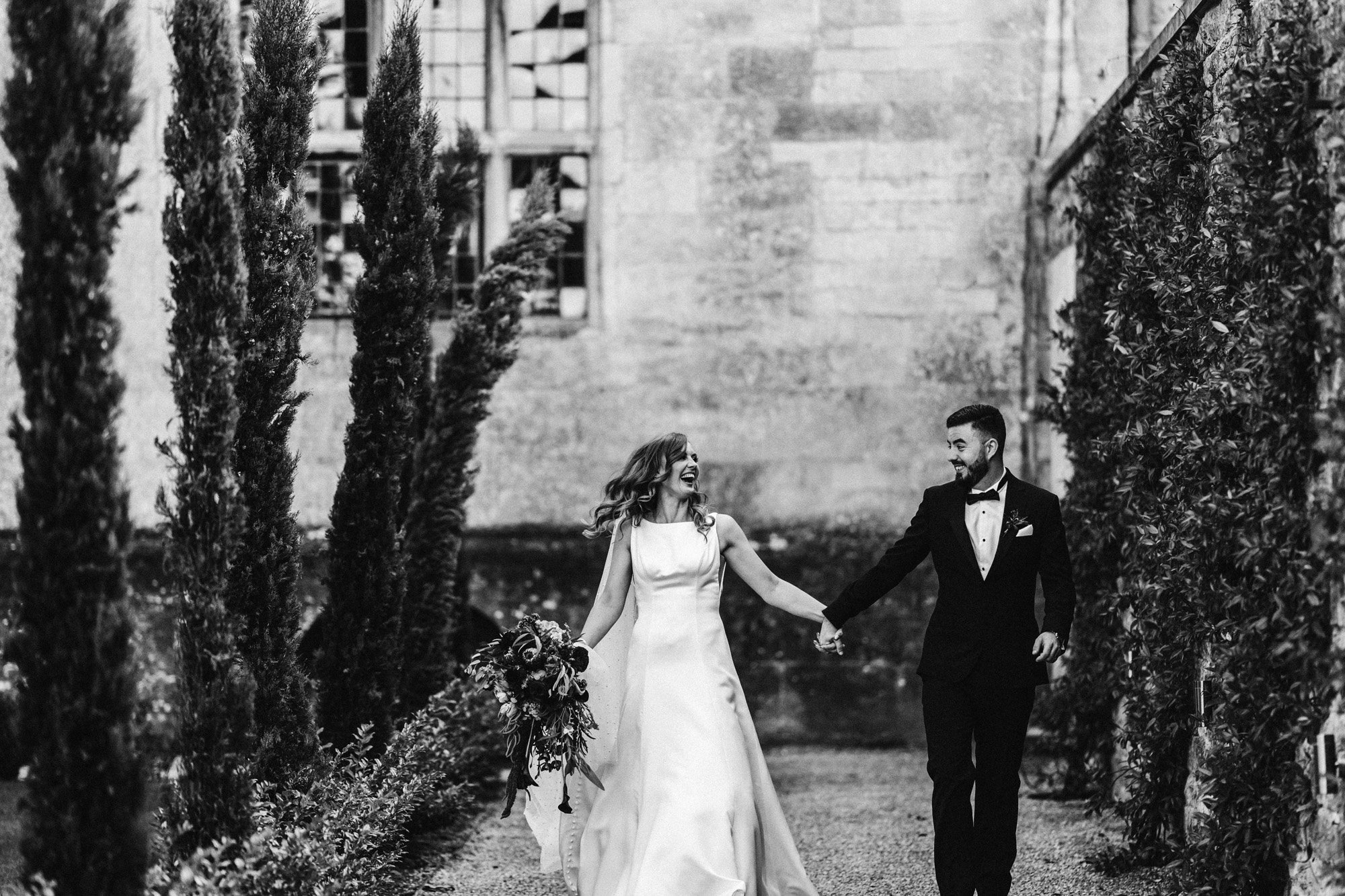 black tie bride and groom laugh their way to wedding party