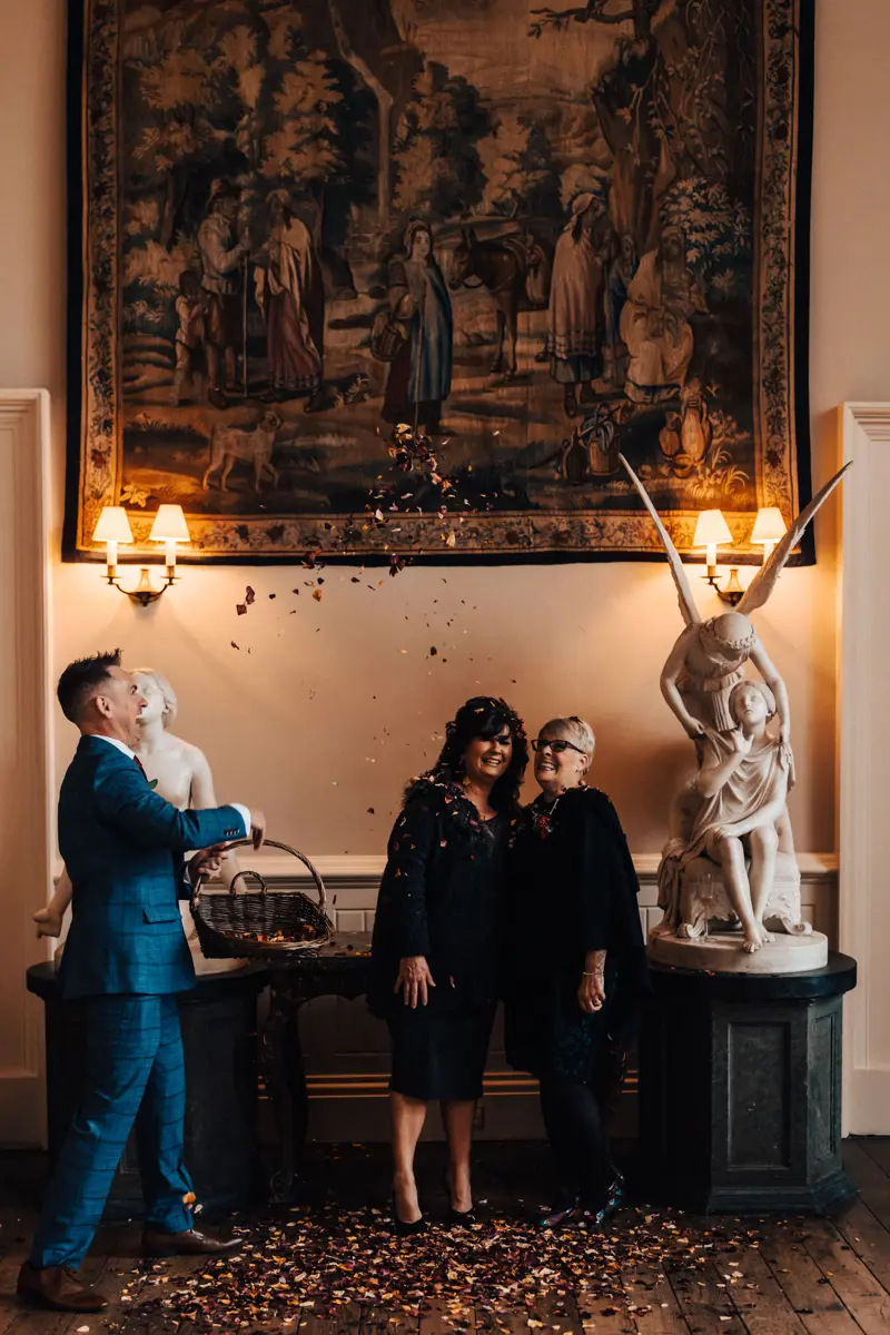 groom throws confetti at mothers on christmas wedding