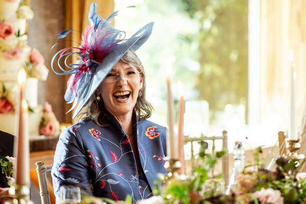 mother of the bride in beautiful outfit of silk pattern jacket and matching hat by shibumi uk
