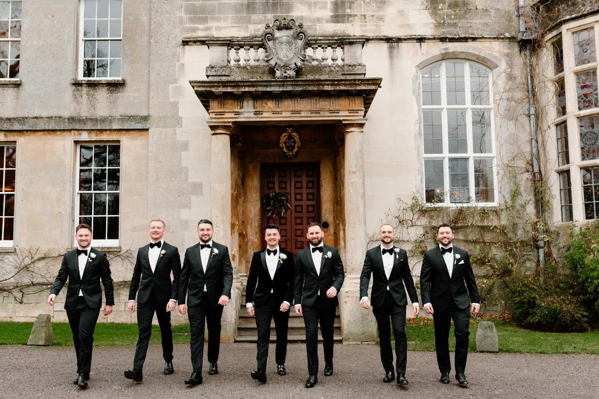 groom and his groomsman lined up outside a stately home in Gloucestershire