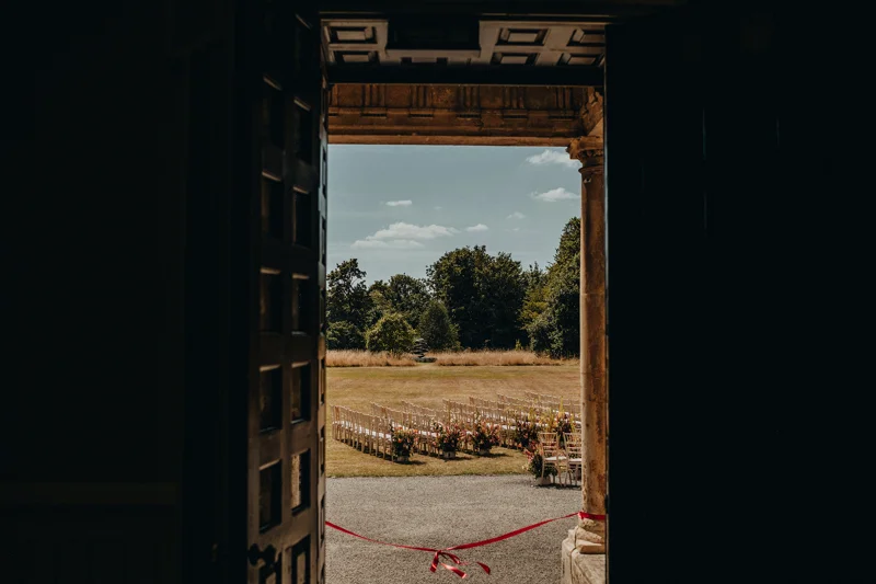 Ribbon tied across door to outdoor wedding ceremony in a beautiful manor house in the countryside