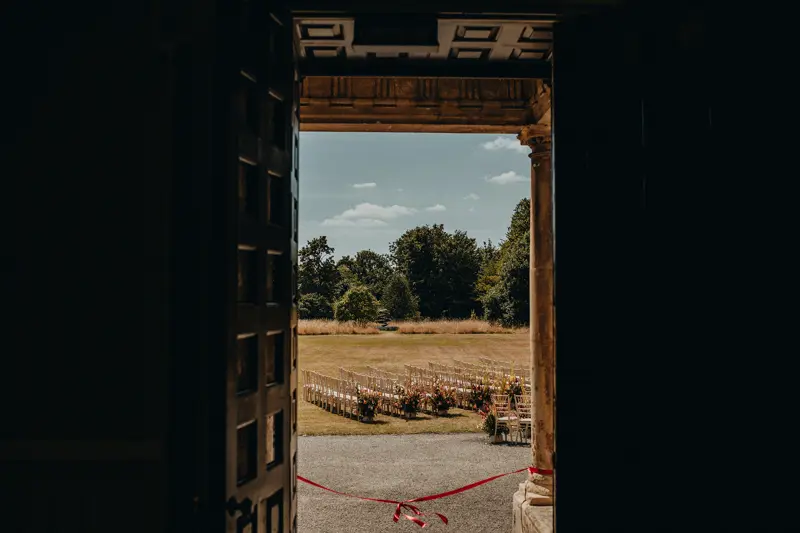 Ribbon tied across door to outdoor wedding ceremony in a beautiful manor house in the countryside
