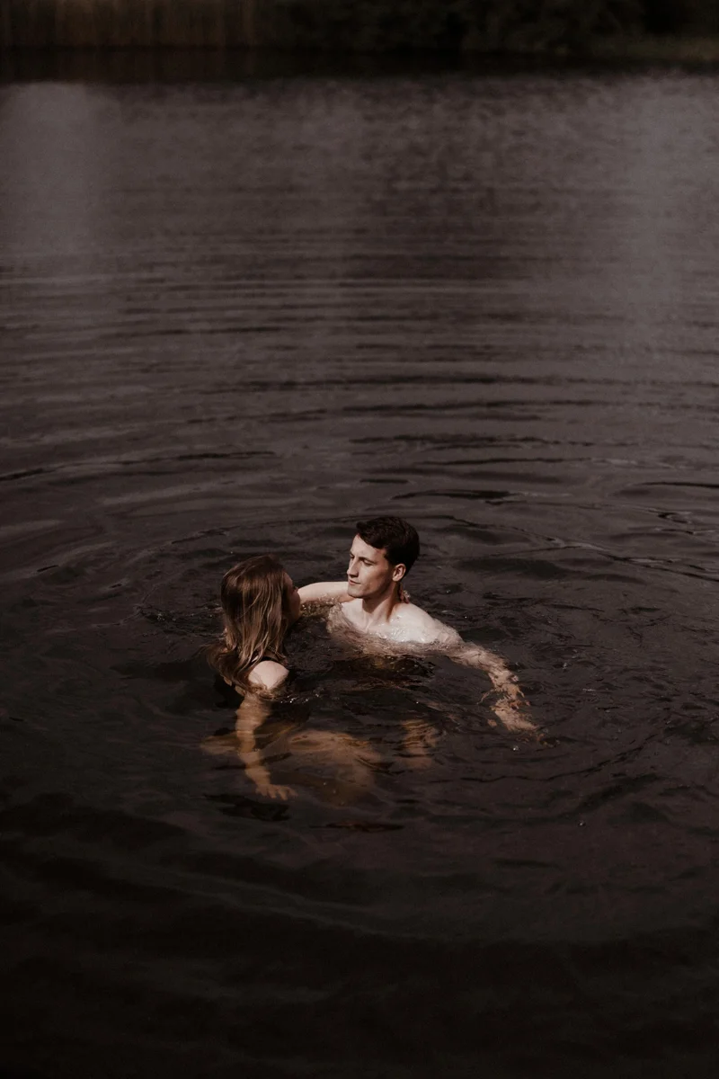 Wild bride and groom swimming in spring fed lake on rewilding land at eco wedding venue elmore court