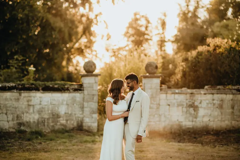 bride embracing her husband at a Gloucestershire wedding venue, outside during a beautiful sunset