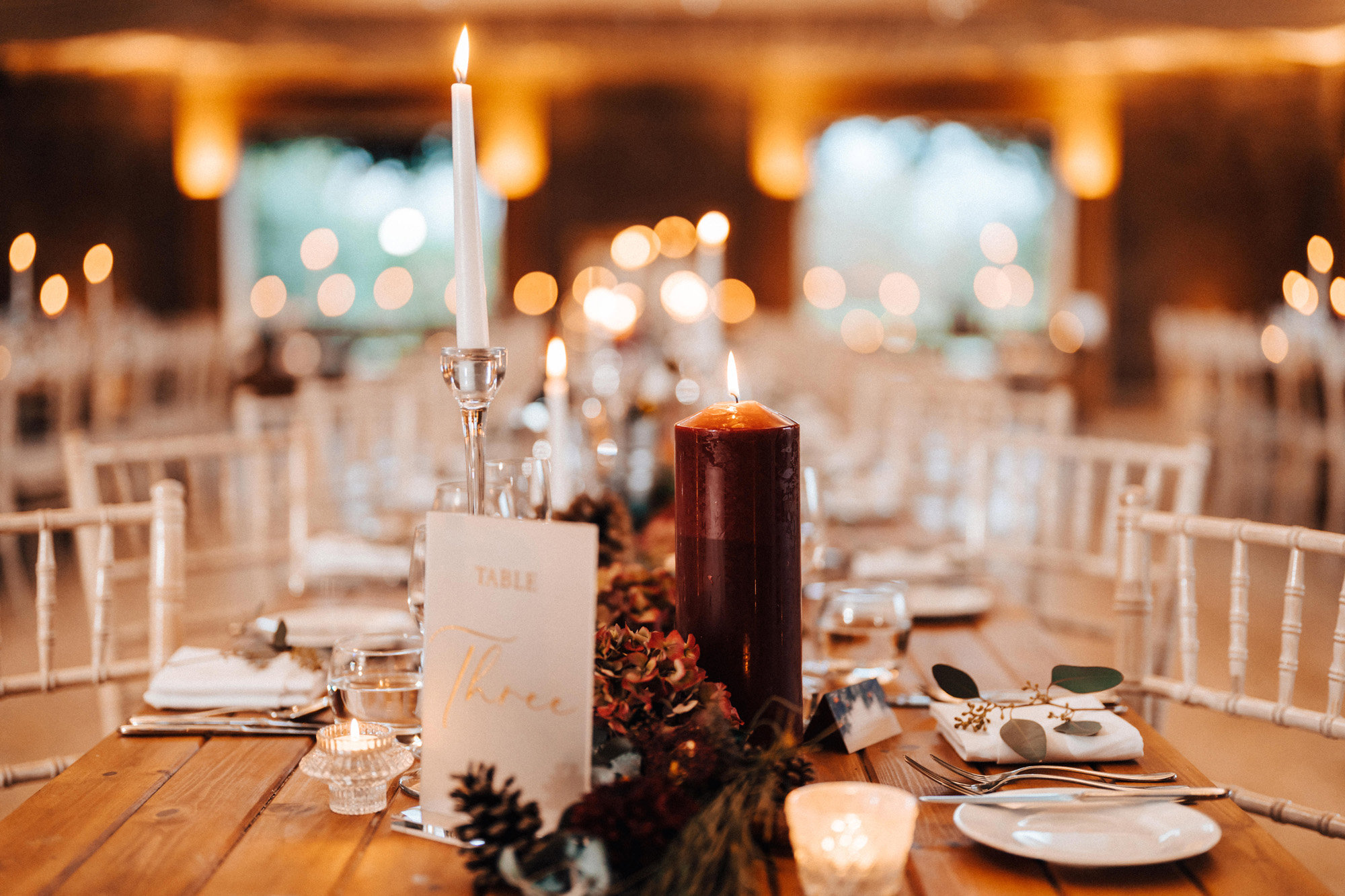 red candles and christmas wedding decor on tables for a magical winter wedding reception in the uk