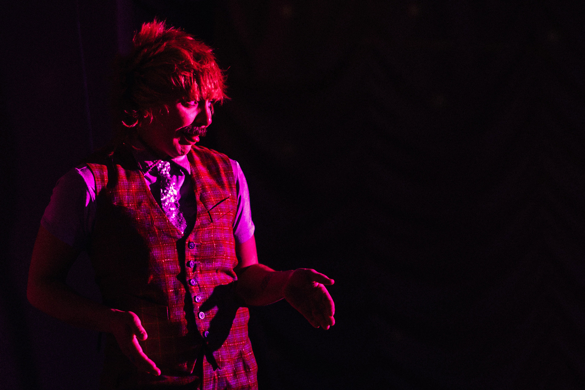 Jess love drag king on stage under red lights at elmore court's pop up covid cabaret