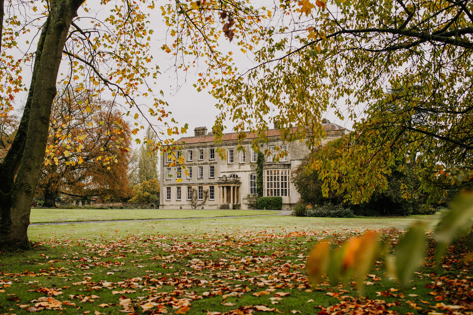 Autumn leaves surrounding stately home elmore court in the cotswolds