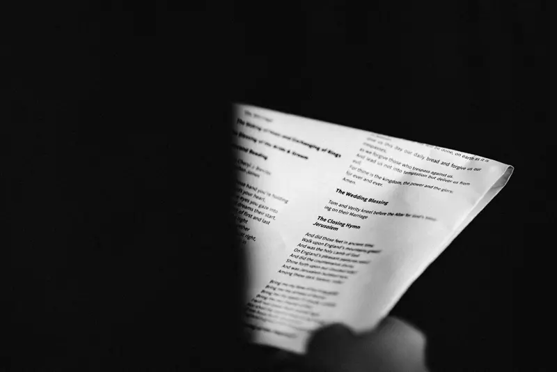 Black and white photo of wedding hymns held in hand