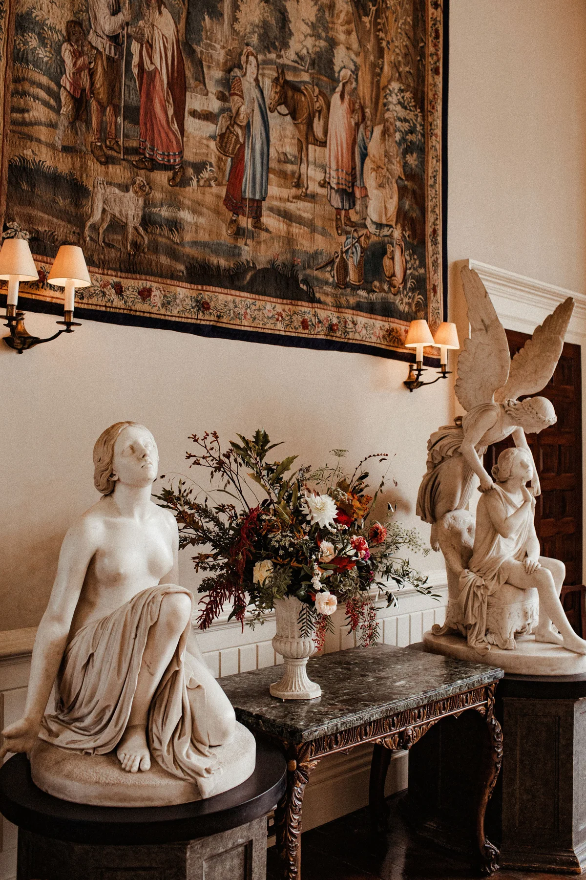 Autumn wedding ceremony decor of flowers and angel statues at stately home in the cotswolds